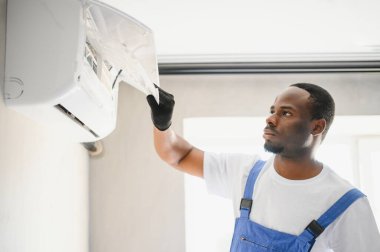 Mutlu genç Afrika erkek teknisyen Klima tamiri.