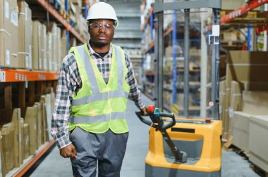 Afro-Amerikan Adam Depoda Çatal Kaldırma Kamyonu Sürüyor.