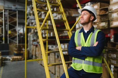 Tulumlu ve kasklı yakışıklı bir depo çalışanının portresi..