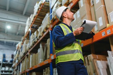 Depo çalışanı portresi, pano teslimatı, depoda stok. Depo çalışanı malları nakliyeye hazırlıyor..