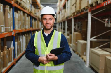 Depo çalışanının portresi elinde pano teslimatı, depoda stok..