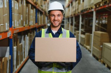 Depo çalışanı teslimat kutusunu tutuyor..