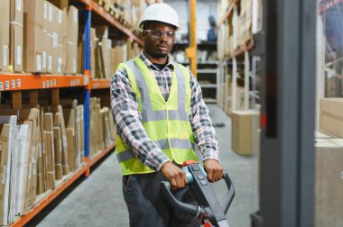 Afro-Amerikan Adam Depoda Çatal Kaldırma Kamyonu Sürüyor.