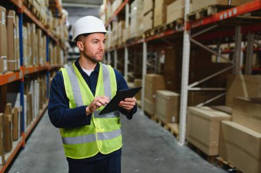 Depo çalışanının portresi elinde pano teslimatı, depoda stok..