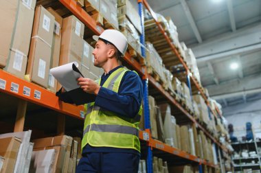 Depo çalışanının portresi elinde pano teslimatı, depoda stok..