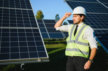 Solar power plant. Man standing near solar panels. Renewable energy.