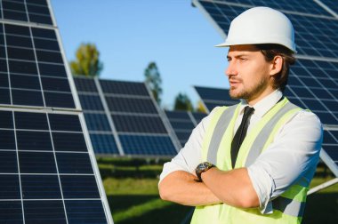 Güneş çiftliği, mühendis ile güneş paneli sistemin işleyişini kontrol eder, dünyanın enerjisini korumak için alternatif enerji, temiz enerji üretimi için fotovoltaik modül fikri.