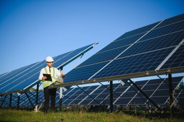 Solar power plant. Man standing near solar panels. Renewable energy.