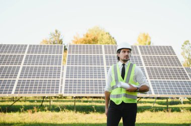Güneş enerjisi istasyonunun planlarını tutan orta yaşlı erkek mühendisin portresi.