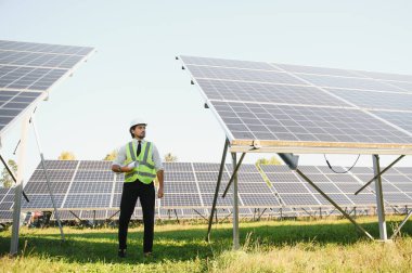 Güneş enerjisi istasyonunun planlarını tutan orta yaşlı erkek mühendisin portresi.