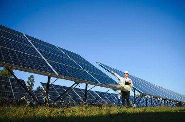 Solar power plant. Man standing near solar panels. Renewable energy.