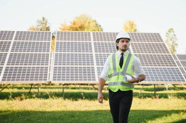 Güneş panellerini inceleyen bir iş adamının portresi. Yeşil enerjiye yatırım kavramı.