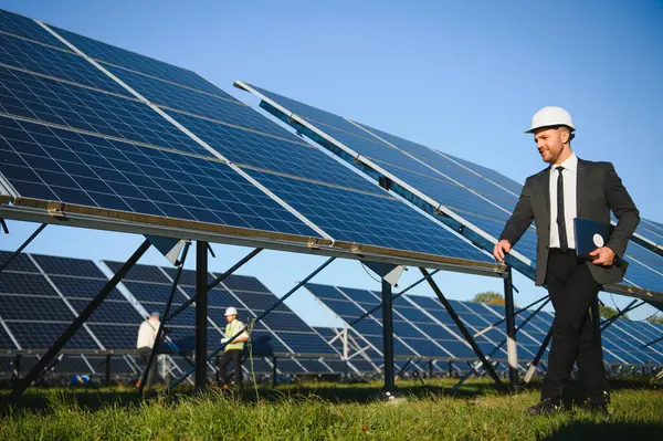 Güneş çiftliği, mühendis ile güneş paneli sistemin işleyişini kontrol eder, dünyanın enerjisini korumak için alternatif enerji, temiz enerji üretimi için fotovoltaik modül fikri.