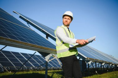 Güneş enerjisi istasyonunun planlarını tutan orta yaşlı erkek mühendisin portresi.