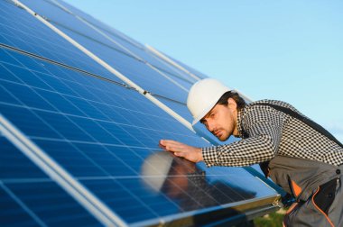 Güneşli bir günde güneş panelleri kuran güneş paneli teknisyeni.