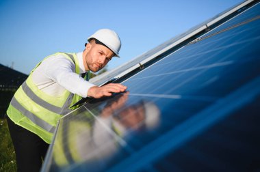 Solar power plant. Man standing near solar panels. Renewable energy.