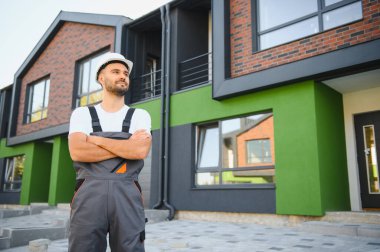 Yeni kulübelerin arka planındaki inşaatçı. Özel kulübelerin inşası konsepti.