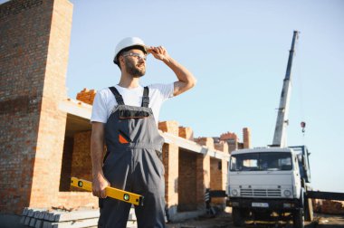 Açık havada inşaat alanında çalışan bir inşaatçının portresi..