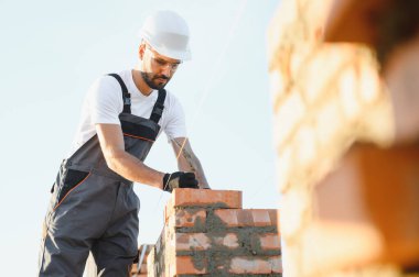 Construction worker in uniform and safety equipment have job on building. Industrial theme.