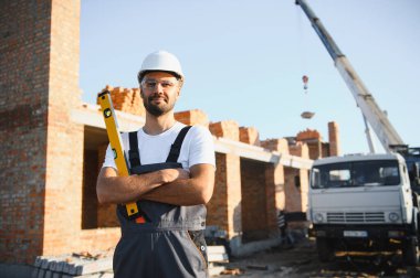 Construction worker in uniform and safety equipment have job on building. Industrial theme.