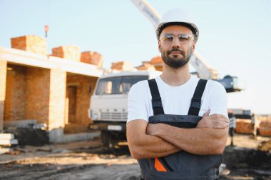 Açık havada inşaat alanında çalışan bir inşaatçının portresi..