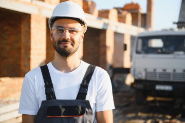 Açık havada inşaat alanında çalışan bir inşaatçının portresi..