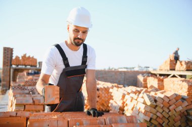 Construction worker in uniform and safety equipment have job on building. Industrial theme.