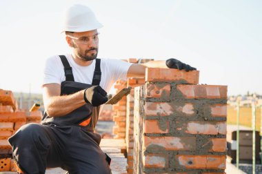 Construction worker in uniform and safety equipment have job on building.