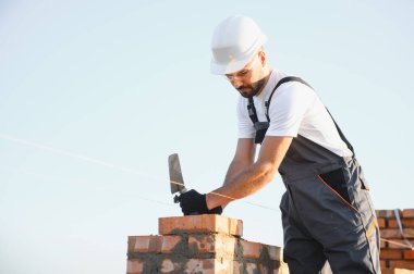 Construction worker in uniform and safety equipment have job on building.