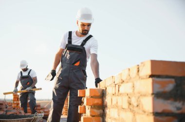 Construction worker in uniform and safety equipment have job on building. Industrial theme.