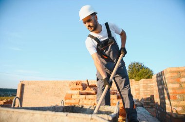 İnşaat mason işçi çimento tuğla açık havada mala macun bıçak ile yükleme.