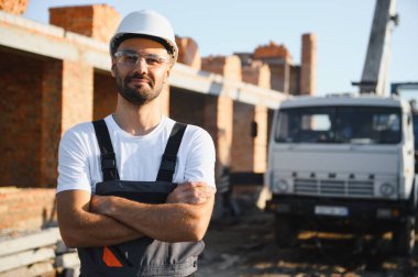 Açık havada inşaat alanında çalışan bir inşaatçının portresi..