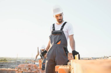 İnşaat mason işçi çimento tuğla açık havada mala macun bıçak ile yükleme.