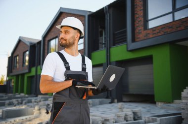 Neşeli yapı yöneticisi yeni kulübe kompleksini inceliyor.