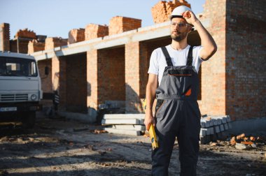 Açık havada inşaat alanında çalışan bir inşaatçının portresi..