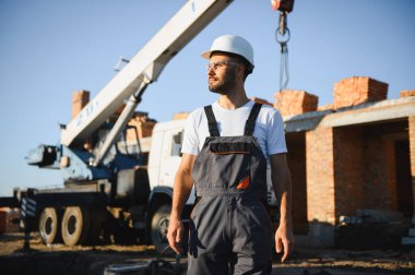 Construction worker in uniform and safety equipment have job on building. Industrial theme.