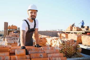 Construction worker in uniform and safety equipment have job on building. Industrial theme.