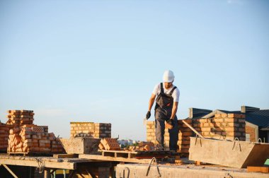 İnşaat alanına tuğla döşeyen bir adam..
