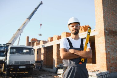 Açık havada inşaat alanında çalışan bir inşaatçının portresi..