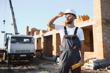 Construction worker in uniform and safety equipment have job on building.
