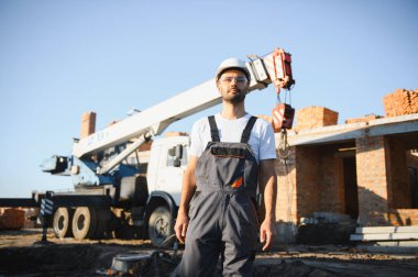İş yerinde çelik yelek ve şapka takan inşaat işçisinin portresi. İnşaat ve ev tadilatı.