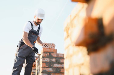Construction worker in uniform and safety equipment have job on building.
