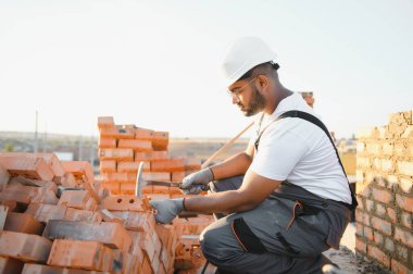 Hintli inşaat işçisi üniforma ve güvenlik ekipmanları inşaatında çalışıyor..