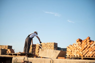 Construction worker in uniform and safety equipment have job on building. Industrial theme.