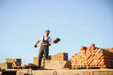 Construction worker in uniform and safety equipment have job on building.