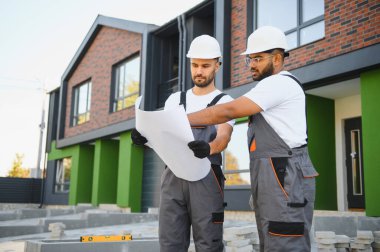 İnşaat müdürüne kır evi cephesini gösteren memnun müteahhit..