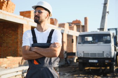 Construction worker in uniform and safety equipment have job on building. Industrial theme.