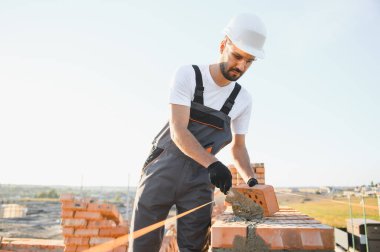 İnşaat mason işçi çimento tuğla açık havada mala macun bıçak ile yükleme.