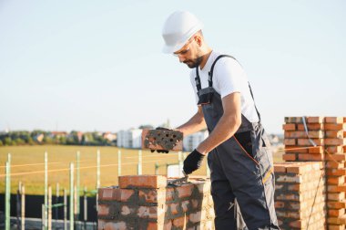 İnşaat mason işçi çimento tuğla açık havada mala macun bıçak ile yükleme.