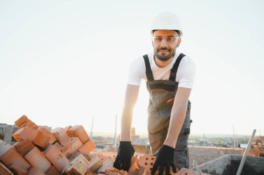 Construction worker in uniform and safety equipment have job on building. Industrial theme.